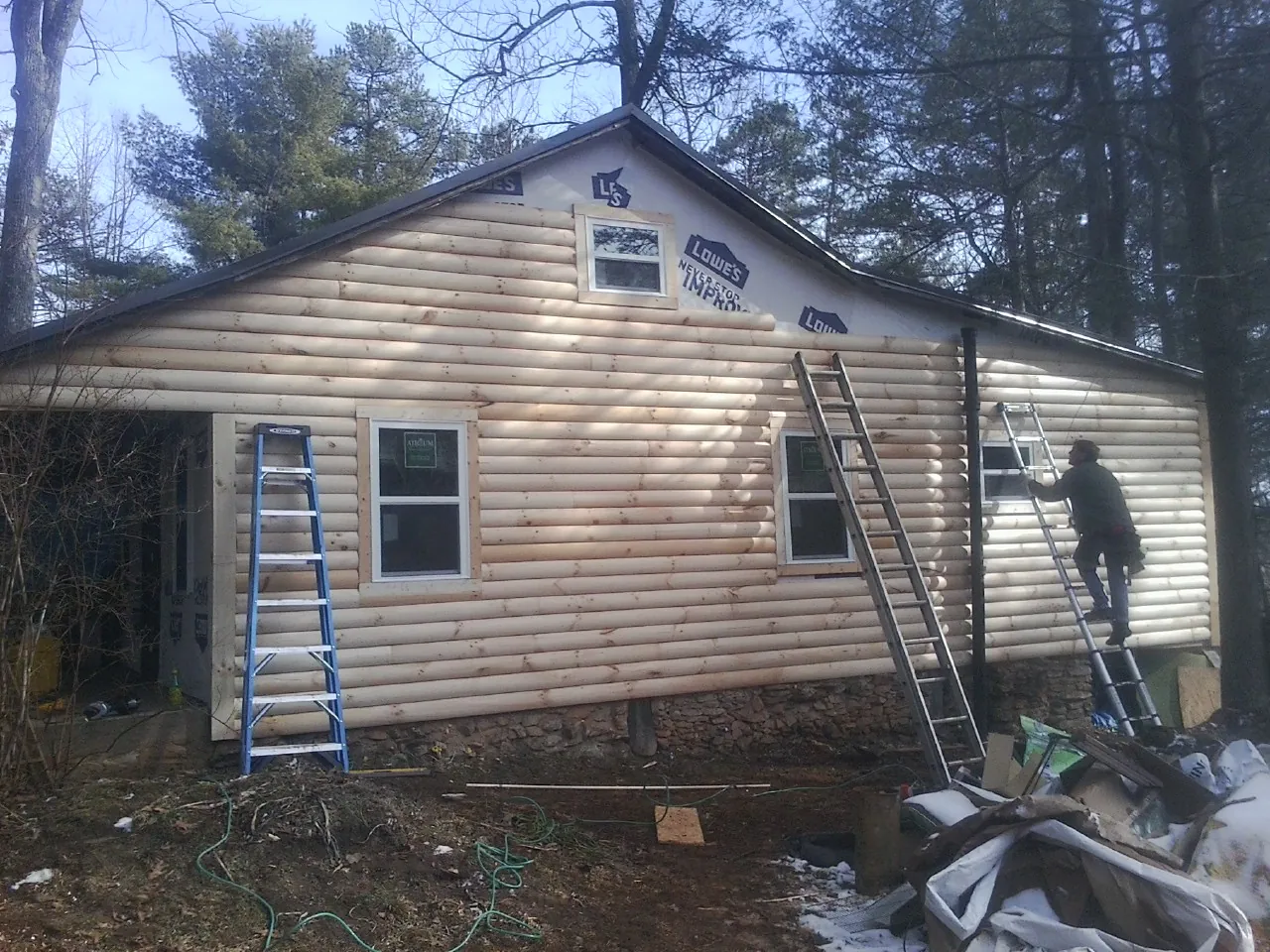 Ladders set against fresh log siding during an exterior remodel in Clendenin