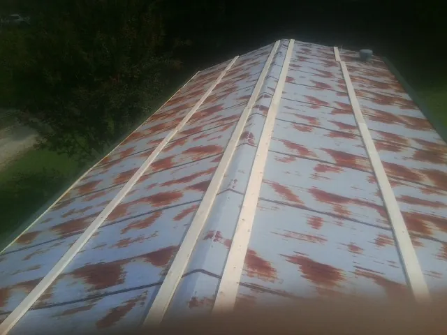 Rusted metal roof panels with new wood purlins before replacement — Storm Damage Roof Repair in Clendenin by Roofing Brothers