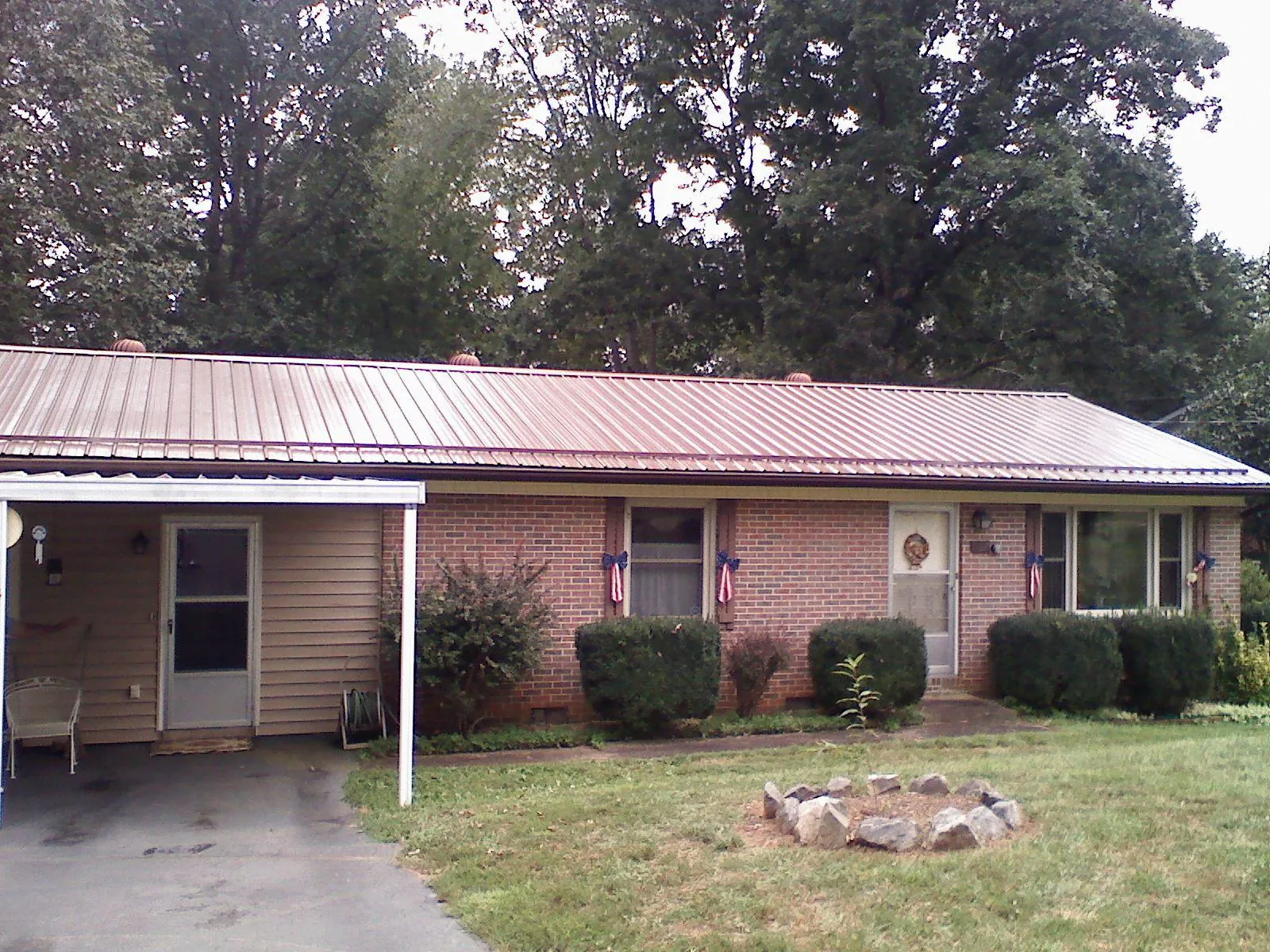 Bronze metal roof and carport on a brick ranch home — Roof Repair work by our crew in Clendenin