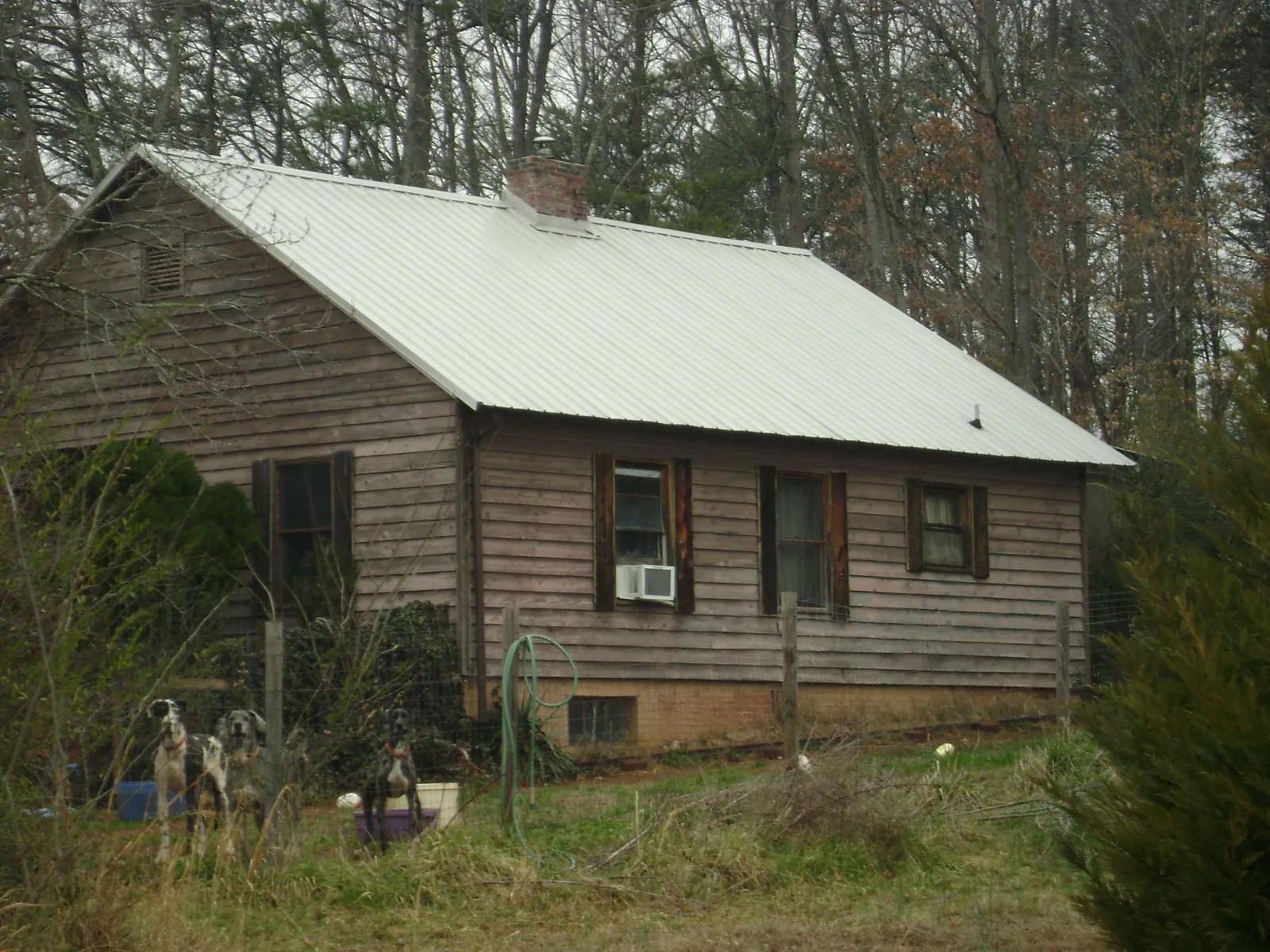 White metal roof on an old wood sided farmhouse, from a Metal Roof Installation job in Clendenin